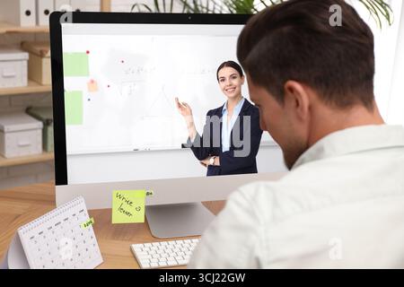 E-Learning-Konzept. Schüler, der Online-Videochat mit dem Lehrer über einen Computer am Schreibtisch führt Stockfoto