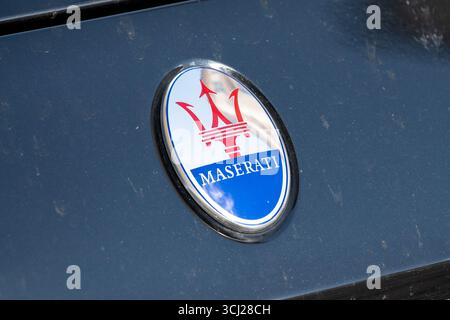Maserati-Logo des italienischen Luxuswagenherstellers. Nahaufnahme des Emblems an der Vorderseite eines blauen Fahrzeugs. Stockfoto