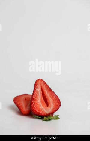 In Scheiben geschnittene Erdbeeren auf weißem Hintergrund Stockfoto