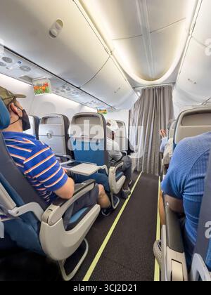 Innenansicht einer Flugzeugkabine von singapore Airways A320 mit Passagieren auf beiden Seiten und Sichtfächern über dem Dach. Stockfoto
