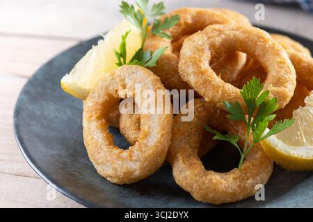 Knusprige gebratene Tintenfischringe auf Holztisch Stockfoto