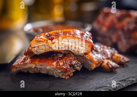 Glasierte Schweinerippchen auf einem schwarzen Tisch. Stockfoto