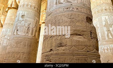 Dendera, Ägypten – 10. Februar 2025: Detaillierte Schnitzereien und Hieroglyphen auf massiven Steinsäulen im antiken Dendera-Tempel in Ägypten. Stockfoto