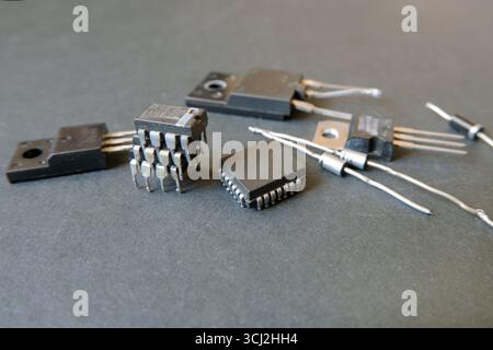 Halbleiterelektronik auf dem schwarzen Boden. Integrierte Schaltungen, Messgeräte und Dioden. Ausgewählter Fokus. Stockfoto