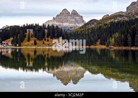 Ein malerischer Blick auf einen ruhigen See in den Dolomiten. Ein großer, felsiger Berg ist über das Wasser zu sehen, seine zerklüfteten Gipfel und die umliegenden Wälder von Evergr Stockfoto