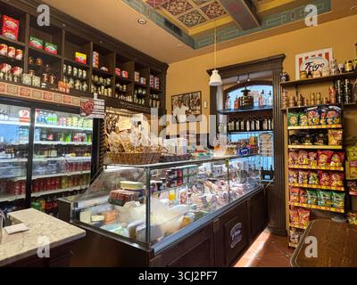 Gemütliches Interieur der traditionellen spanischen Tapas-Bar in Cadiz, mit Holztheken, hängenden Schinken, bunten Fliesen, kleinen Tellern und Wein. Stockfoto
