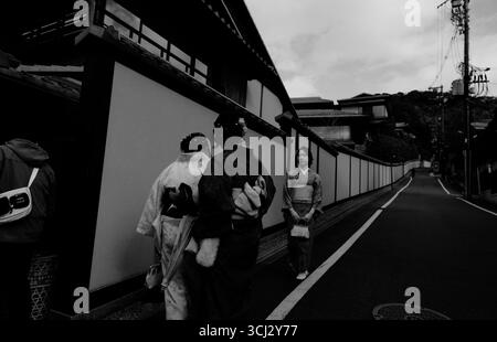 Schwarzweiß-Straßenfoto in Kyoto mit Frauen im Kimono Stockfoto
