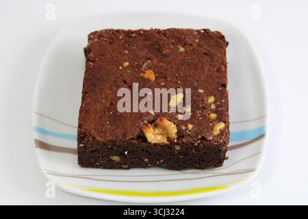 Schokoladenbrownie mit Nüssen auf einer Keramikplatte Stockfoto