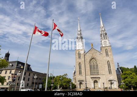 Ottawa, Kanada - 13. Juni 2025: Basilika Notre-Dame und kanadische Flaggen in Ottawa Stockfoto