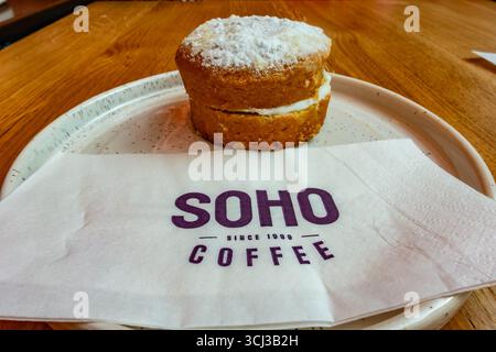 Ein Mini-Victoria-Biskuitkuchen auf einem Teller bei Soho Coffee in London, Großbritannien Stockfoto