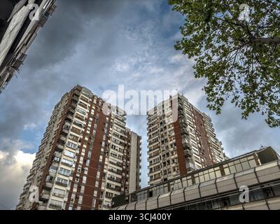 Verwitterte Wohnungstürme aus der sozialistischen Ära dominieren die Skyline von Belgrad, in serbien mit Betonfassaden, die unter einem brütenden Himmel verstreut sind Stockfoto