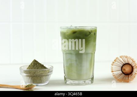 Hausgemachter Ice Matcha Latte Green Tea. Ein Glas weiß und grün cremiges kaltes Getränk Milch und Matcha Green Tea isoliert auf weiß Stockfoto