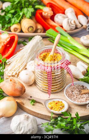 Hausgemachtes Gemüsebrühen-Pulver, Bio-Gemüsebrühe, mit rohem Gemüse, Pilzen und Kräutern Stockfoto