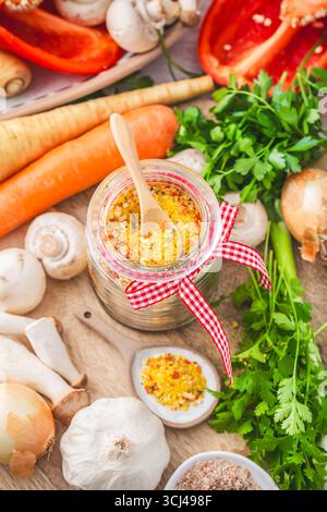 Hausgemachtes Gemüsebrühen-Pulver, Bio-Gemüsebrühe, mit rohem Gemüse, Pilzen und Kräutern Stockfoto