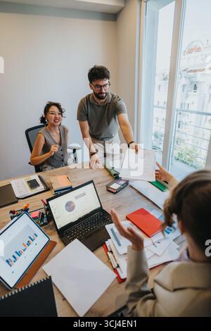 Ein junges Paar in einer Bank, das mit einem Finanzberater über Darlehensoptionen diskutiert Stockfoto