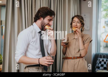 Kollegen genießen Snacks und Getränke während einer gemeinsamen Büropause Stockfoto