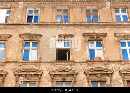 Berlin, Deutschland - 17. August 2025: Fassade eines alten Gebäudes in Berlin mit detailliertem Mauerwerk, bunten Fenstern und einem klaren blauen Himmel darüber. Stockfoto