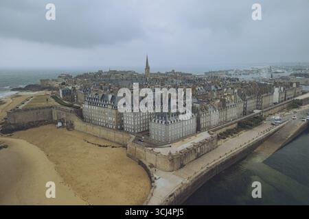 Aus der Vogelperspektive der alten Festungsmauern umrahmt die Stadt, im Kontrast zum stimmungsvollen Himmel über Saint-Malo, Bretagne, Frankreich. Stockfoto