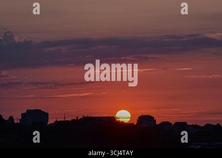 Sonnenuntergang über der Skyline der Stadt mit magischen Himmelsfarben, sanftem Licht und urbanen Silhouetten im warmen Abendglühen. Stockfoto