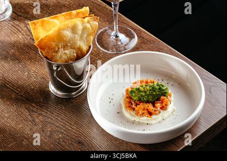 Forelle Tartar mit Soße und einem Glas Wein Stockfoto