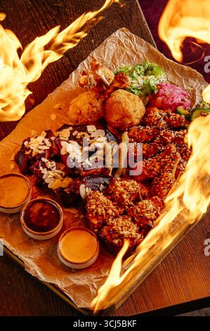 Set mit Fleisch und Hähnchenflügeln, Soße und Gemüse Stockfoto