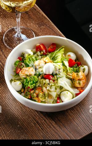 Caesar Salat mit Garnelen und einem Glas Wein Stockfoto