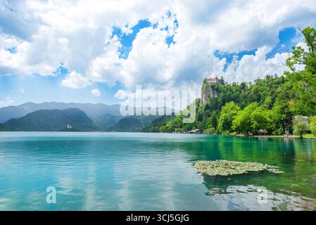 Bled, Slowenien – 22. Juni 2024: Malerischer Blick auf den Bleder See mit Schloss Bled auf Klippen und ruhigem türkisfarbenem Wasser Stockfoto