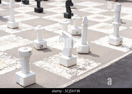 Riesiges Freiluftschachspiel mit weißen und schwarzen Stücken auf dem öffentlichen Platz in Salzburg Stockfoto
