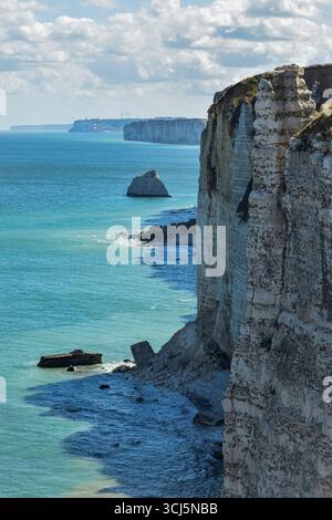 Vertikales Sommerpanorama der legendären Klippen von Etretats in der Normandie, mit lebendigem türkisfarbenem Meer, strukturierten Wellen und hoch aufragenden weißen Felsformationen in Grün - ein atemberaubender Küstenort. Stockfoto