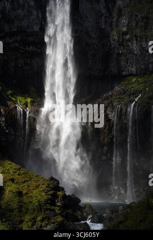 Wunderschöner starker Wasserfall, der den massiven felsigen Berg von nikko japan hinunterragt und die Sonne im fließenden Wasser reflektiert und einen kleinen See bildet Stockfoto