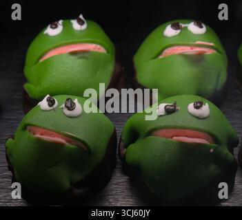 Dänischer Kajkager oder Froschkuchen, benannt nach der Kinderserie Frog Kaj. Grüner Marzipan, der Erdbeercreme auf süßem Gebäck oder Schwämmchen überzieht. Stockfoto
