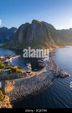 Aus der Vogelperspektive auf die Insel Hamnøya und den Berg Lilandstinden in der reine-Bucht während des Sommersonnenaufgangs bei Mitternachtssonne. Lofoten-Inseln, Norwegen. Stockfoto