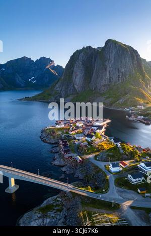 Aus der Vogelperspektive auf die Insel Hamnøya und den Berg Lilandstinden in der reine-Bucht während des Sommersonnenaufgangs bei Mitternachtssonne. Lofoten-Inseln, Norwegen. Stockfoto
