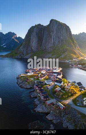 Aus der Vogelperspektive auf die Insel Hamnøya und den Berg Lilandstinden in der reine-Bucht während des Sommersonnenaufgangs bei Mitternachtssonne. Lofoten-Inseln, Norwegen. Stockfoto