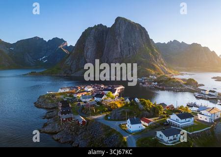 Aus der Vogelperspektive auf die Insel Hamnøya und den Berg Lilandstinden in der reine-Bucht während des Sommersonnenaufgangs bei Mitternachtssonne. Lofoten-Inseln, Norwegen. Stockfoto