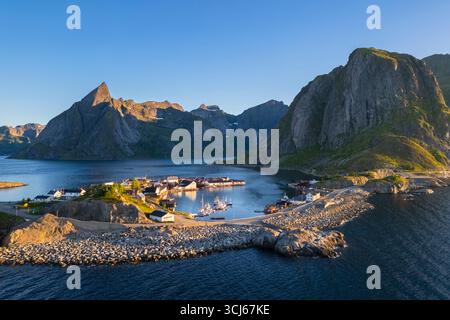 Aus der Vogelperspektive auf die Insel Hamnøya und den Berg Lilandstinden in der reine-Bucht während des Sommersonnenaufgangs bei Mitternachtssonne. Lofoten-Inseln, Norwegen. Stockfoto