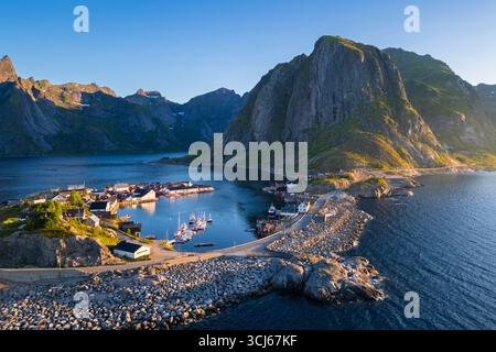 Aus der Vogelperspektive auf die Insel Hamnøya und den Berg Lilandstinden in der reine-Bucht während des Sommersonnenaufgangs bei Mitternachtssonne. Lofoten-Inseln, Norwegen. Stockfoto