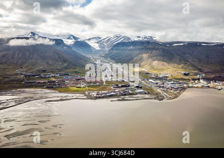 Longyearbyen Svalbard Norwegen // LONGYEARBYEN, SVALBARD UND JAN MAYEN — ein Luftbild fängt die Siedlung Longyearbyen ein, eingebettet in ein Tal und entlang der Küste des Adventfjordens. Diese arktische Stadt ist das Verwaltungszentrum und die größte Siedlung im Svalbard-Archipel. Das Bild zeigt die charakteristischen bunten Gebäude der Stadt, die sich über die Landschaft verteilen, mit schneebedeckten Bergen im Hintergrund. Longyearbyen ist einer der nördlichsten bewohnten Orte der Welt und dient als Drehscheibe für Forschung und Tourismus in der hohen Arktis. Der surr Stockfoto