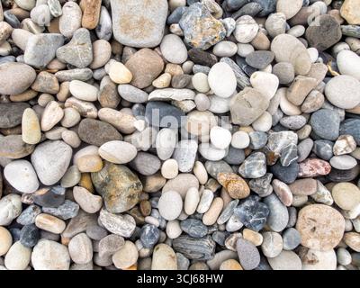Kieselsteine am Strand Hornsund Svalbard Norwegen // HORN SUND, SVALBARD — Eine Nahansicht zeigt eine Sammlung von glatten, abgerundeten Kieselsteinen an einem Strand in Hornsund. Die Kieselsteine zeigen eine Vielzahl von Farben, darunter Grautöne, weiß, Braun und Schwarz, wobei einige subtile Variationen in der Textur und in Mineraleinschlüssen aufweisen. Hornsund ist ein Fjord an der Südküste Spitzbergens, der größten Insel des Svalbard-Archipels in Norwegen. Der Svalbard-Archipel liegt im Arktischen Ozean, auf halbem Weg zwischen dem norwegischen Festland und dem Nordpol. Diese Inseln sind bekannt für ihre dramatischen Landschaften Stockfoto