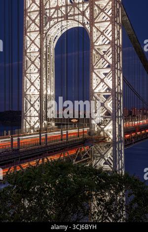 GW Bridge das beleuchtete Gateway V - die Türme der George Washington Bridge leuchten vor dem tiefen Blau des Nachthimmels. Stockfoto