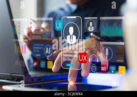 Nahaufnahme eines Geschäftsmanns, der Hand an einem Laptop mit UI- und UX-Symbolen, künstlicher Intelligenz, Datenanalyse und digitaler Schnittstellentechnologie für Mob arbeitet Stockfoto