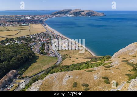 Blick aus der Vogelperspektive auf die Llandudno Bay mit der weiten Küste, der Stadt und den felsigen Hügeln in der Sommersonne. Stockfoto