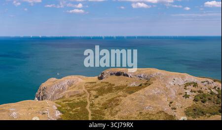 Aus der Vogelperspektive von den Little Orme Klippen von Llandudno auf das Meer mit einem Offshore-Windpark, der am Horizont sichtbar ist. Stockfoto