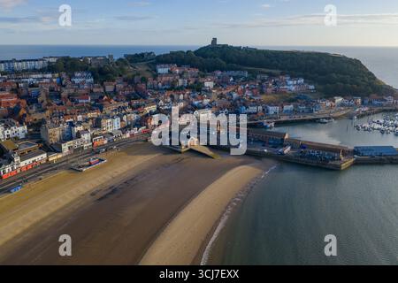 Panoramablick auf Scarborough am Morgen, mit dem breiten Sandstrand im Vordergrund, farbenfrohen Stadtgebäuden entlang der Promenade. Stockfoto
