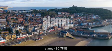 Panoramablick auf Scarborough am Morgen, mit dem breiten Sandstrand im Vordergrund, farbenfrohen Stadtgebäuden entlang der Promenade. Stockfoto