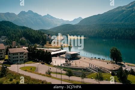 Atemberaubender Panoramablick über den St. Moritz See, umgeben von üppigen Alpenwäldern und Berggipfeln an einem hellen Sommertag. Perfekt für Reisen, Tourismus, Stockfoto