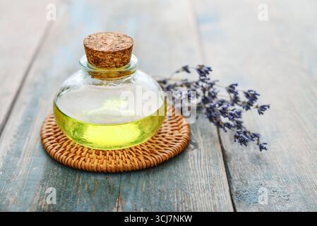 Ätherisches Lavendelöl in Glasflasche mit Lavendelblüten, Clocup. Konzept der alternativen Medizin. Stockfoto