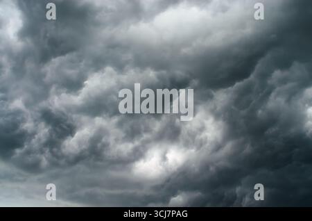 Kumulusgraue Sturmwolken bilden einen dramatischen, strukturierten Himmel, der eine stimmungsvolle und kraftvolle Naturwetter-Hintergrundszene erzeugt Stockfoto