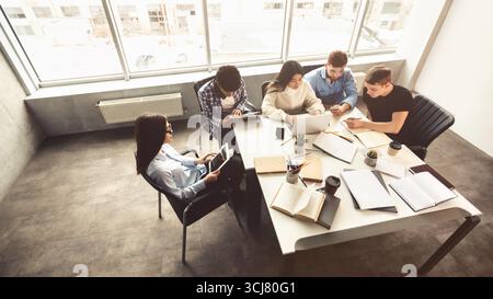 Schüler, die Gruppenprojekte in der Bibliothek durchführen, freien Speicherplatz Stockfoto