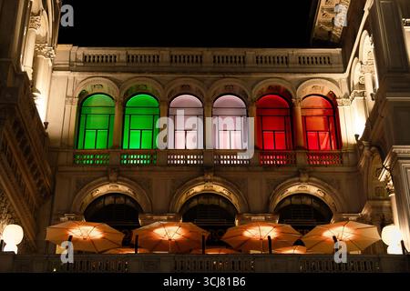 Nachtansicht auf die Fassade der Galleria Vittorio Emanuele II, beleuchtet mit italienischen Flaggenfarben grün, weiß und rot. Stockfoto